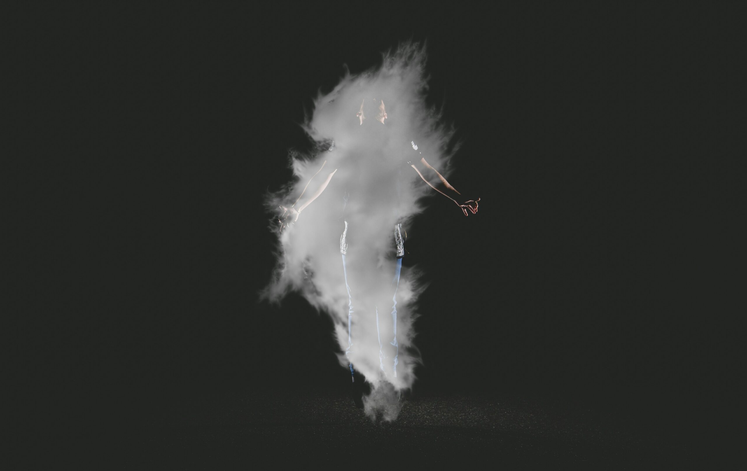 The fog surrounds a young man on a black background.