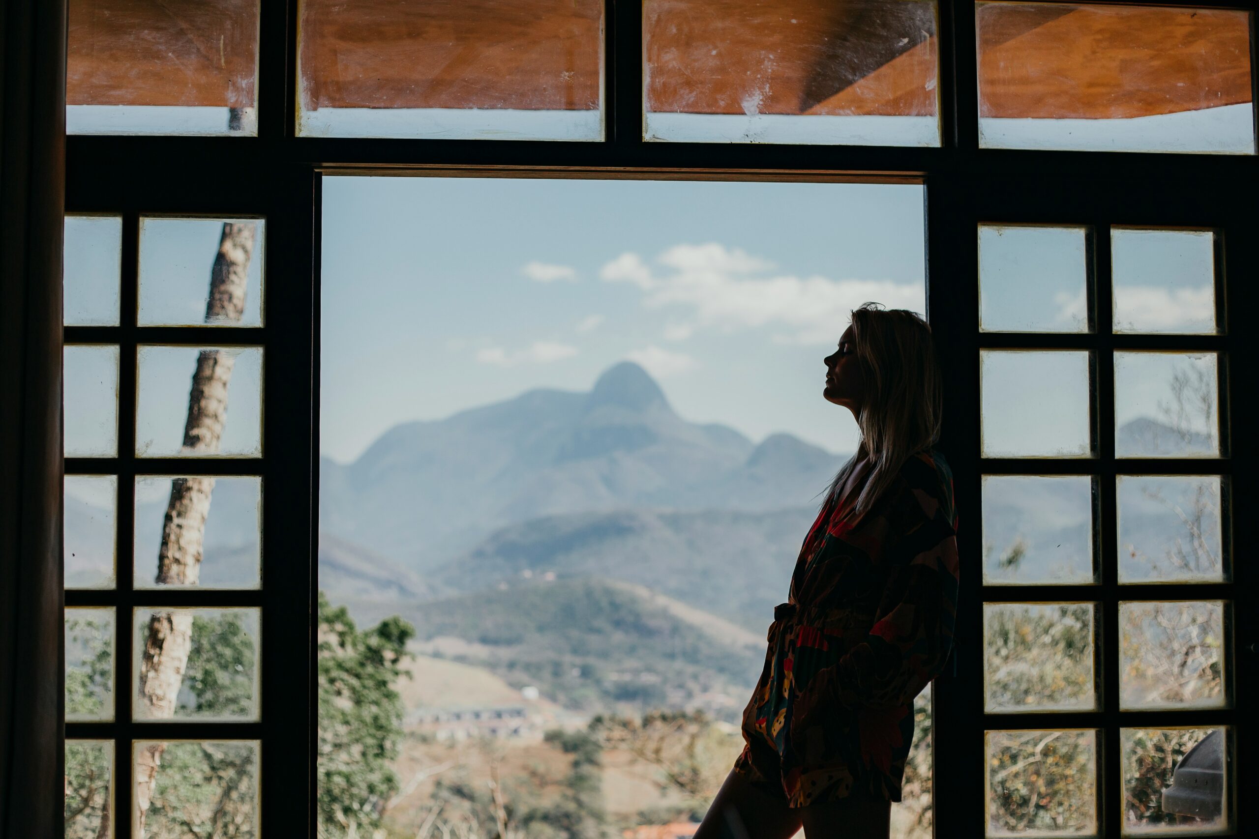 A young woman rests against the door, contemplating creation.